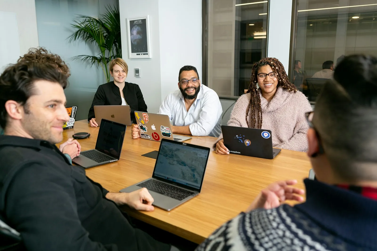 Equipe reunida em volta de uma mesa de trabalho, conversando